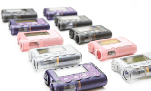 Two rows of different colored insulin pumps in black, purple, pink & clear